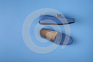 Blue suede man`s mocassin shoes over blue background