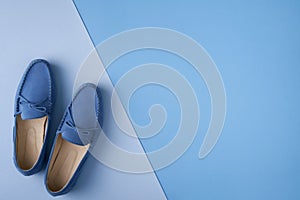 Blue suede man`s mocassin shoes over blue background