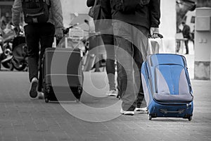 Blue Suitcase with tourist. Black and white background.