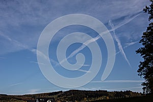 Blue summer sky with contrails in the sky