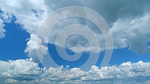 Blue summer sky with thick thunderstorm clouds moving across. Dark grey storm clouds. Time lapse.