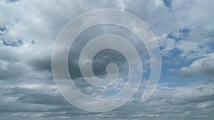 Blue summer sky with thick thunderstorm clouds moving across. Dark grey storm clouds. Timelapse.