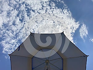Blue sun umbrella on sky background