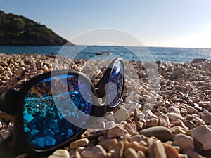 Blue sunglasses on the beach photo