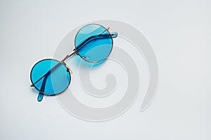 Blue sunglasses. Summer set for relaxing in the hot season. Sea, sand and sun. Looking through the blue glasses.