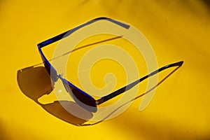 Blue Sunglasses on a yellow Sunbed