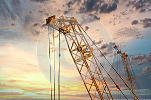 Blue sunset sky after five big high cranes under a new construction site of high-rise building against blue sunset sky