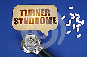 On the blue surface of the tablet, a stethoscope and a cardboard sign with the inscription - Turner syndrome