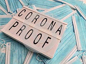 Blue surgical face masks with a white light box stating Corona Proof