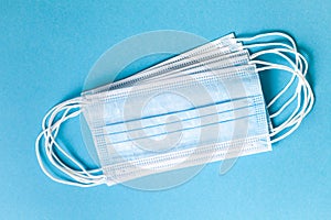 Blue surgical mask on light blue background. Disposable hygienic mask against Coronavirus Covid-19. Protection against flu,