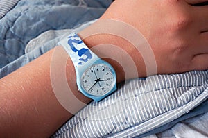 Blue Swatch watch on teenager`s hand