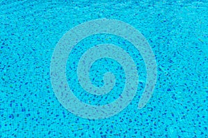 Blue swimming pool rippled water .