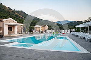 Blue swimming pool in a spa hotel in southern Italy at sunset