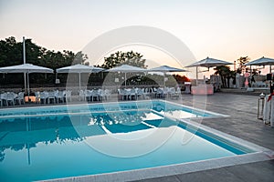 Blue swimming pool in a spa hotel in southern Italy at sunset