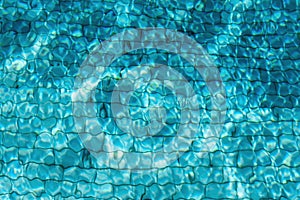 Blue swimming pool water background. Copy space, top view. Close up abstract water texture.