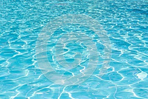 Blue swimming pool water surface and ripple wave background. Summer abstract reflection caustics in swimming pool