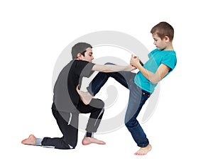 In the blue T-shirt boy is doing armlock on a boy in a black T-shirt