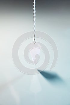 Blue Table with reflections and a crystal pendulum, esoteric and spirituality photo