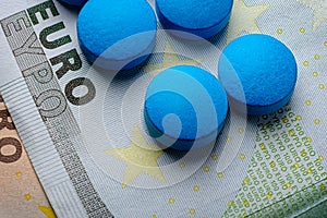 Blue tablets pill macro on 100 euro bill. Drug abuse
