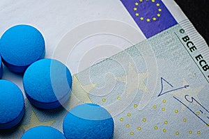 Blue tablets pill macro on euro bill. Drug abuse. Copyspace