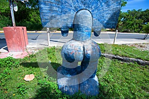 Blue Taino idol on grass back view