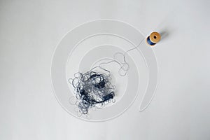 Blue tangle thread spool over white