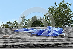 Blue Tarp Covering Residential Roof Leak photo