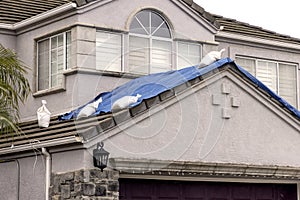 Blue tarp with sandbags on a house roof