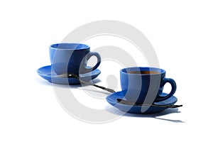 Blue tea cups and tea saucers with iron teaspoons on white background