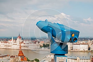 Blue telescope and blurred Budapest city on background