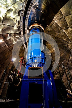 A blue telescope is inside a large building