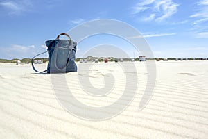 Blue textile beach bag on a sandy tropical beach