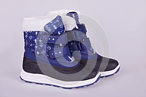 Blue textile and ruber snow boots on white background.