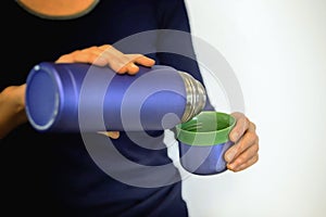 Blue thermos in a womans hands