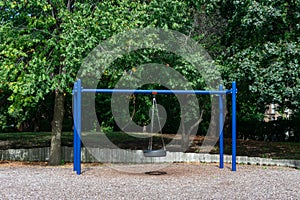 Blue Tire Swing at a Playground during the Summer with Green Trees