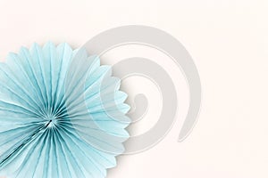 Blue tissue paper fan on a gray background.