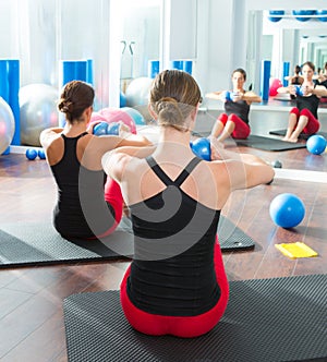 Blue toning ball in women pilates class rear view