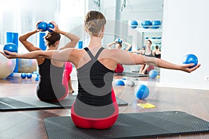 Blue toning ball in women pilates class rear view