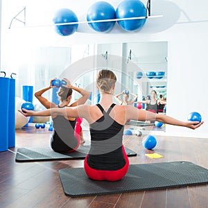 Blue toning ball in women pilates class rear view photo