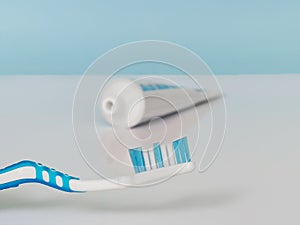 Blue toothbrush and toothpaste on a white blue background. The concept of daily dental care