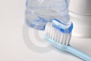 Blue toothpaste on a toothbrush on white background