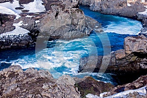 Blue, torrential river surrounded by lava rock