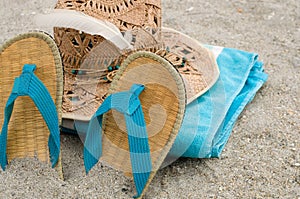 Blue Towel, Sandals and Straw Hat in the Sand