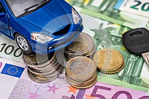 Blue toy car with key, euro bills