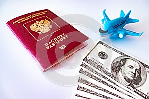 Blue toy plane, russian international passport and cash dollars on white background. Travel, migration and downshifting concept