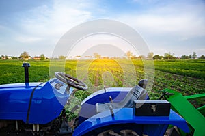 Blue tractor on farm field. Agricultural machinery and technology. Farming and vegetable growing. Modernization. Subsidies and tax