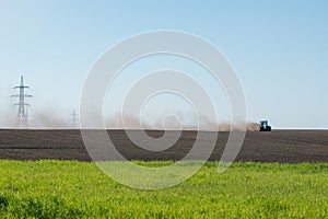 Blue tractor plowing field