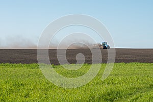 Blue tractor plowing field