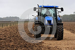 Blue tractor tilling