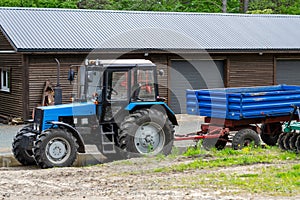 Blue tractor with trailer on the farm